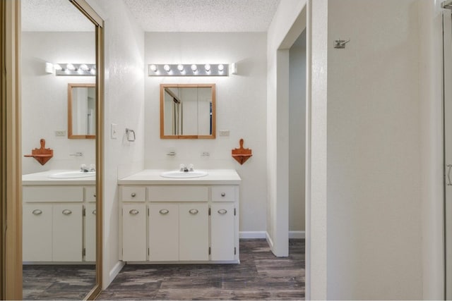 bathroom with vanity, a textured ceiling, and wood-type flooring