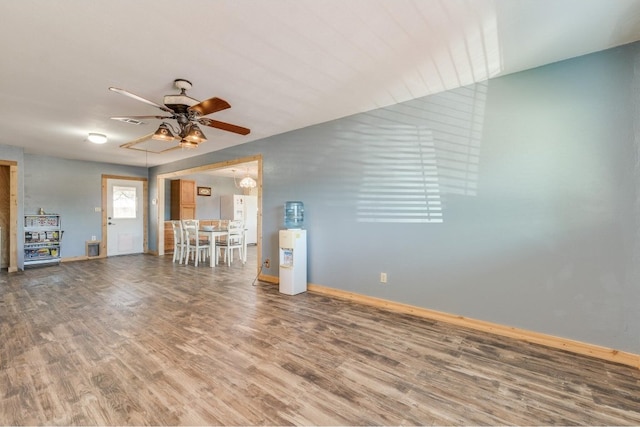 unfurnished living room with wood-type flooring and ceiling fan