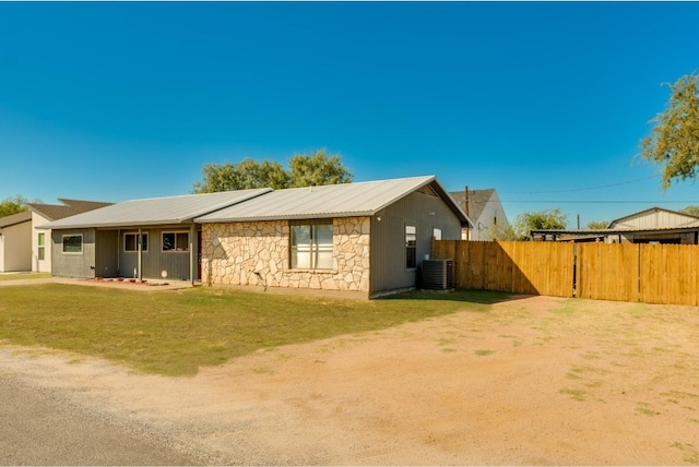 rear view of house with a yard and central air condition unit