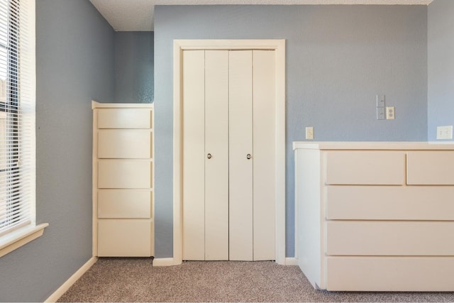 unfurnished bedroom with a closet, multiple windows, and light colored carpet