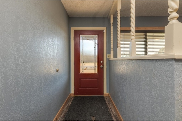 doorway to outside featuring a textured ceiling