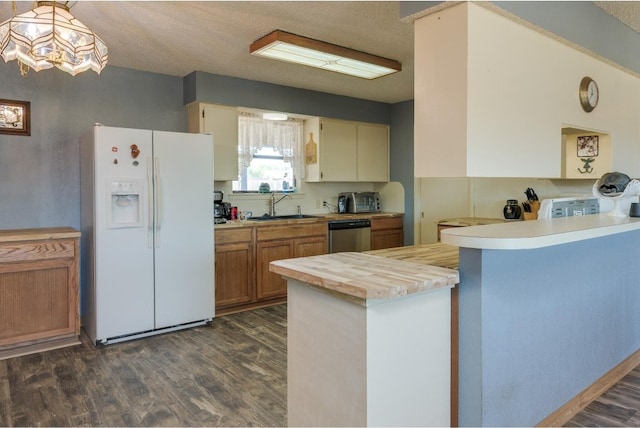 kitchen with white fridge with ice dispenser, kitchen peninsula, dark hardwood / wood-style floors, and decorative light fixtures