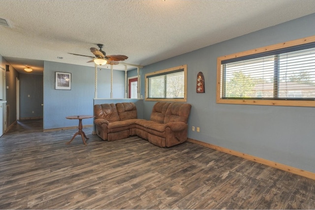 living room with a textured ceiling, dark wood-type flooring, plenty of natural light, and ceiling fan