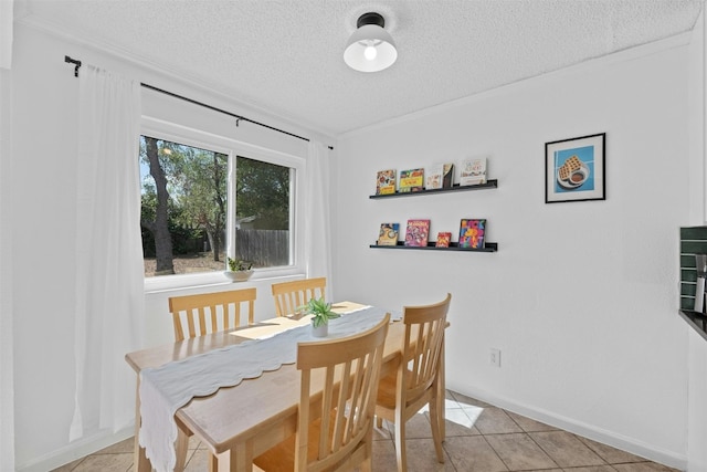 tiled dining space featuring a textured ceiling