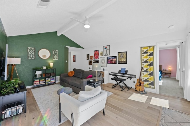 living room featuring vaulted ceiling with beams, light wood-type flooring, and ceiling fan