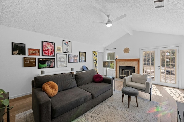 living room featuring french doors, vaulted ceiling with beams, wood-type flooring, and plenty of natural light