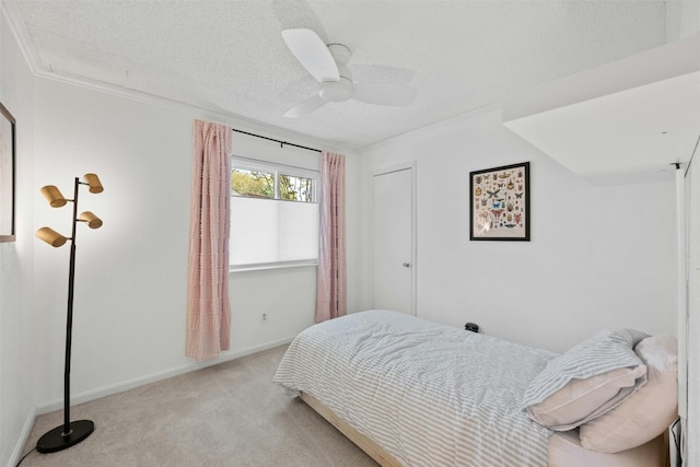 carpeted bedroom with crown molding, a textured ceiling, and ceiling fan