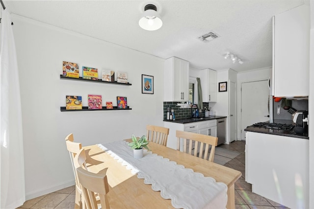 dining room featuring a textured ceiling, light tile patterned flooring, and sink