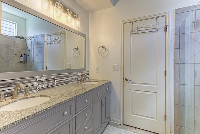 bathroom with vanity, tasteful backsplash, a tile shower, and tile patterned floors