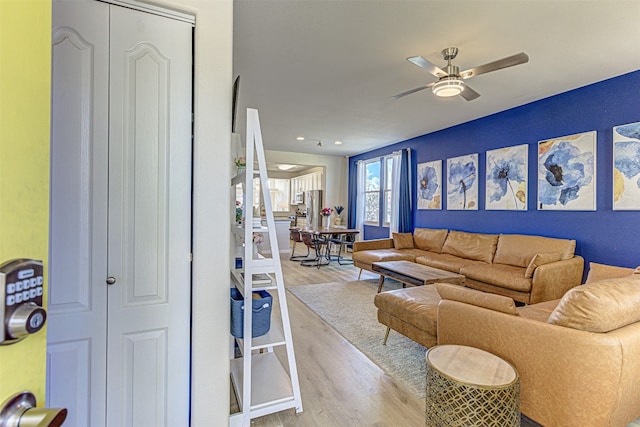 living room with light hardwood / wood-style flooring and ceiling fan