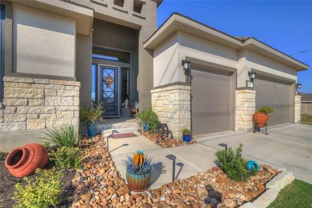 505 John Price St, Blanco, TX 78606 - doorway to property featuring stone siding, stucco siding, an attached garage, and driveway