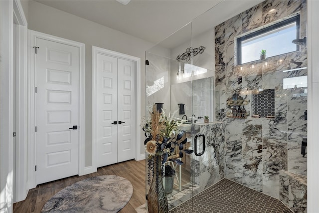 bathroom with hardwood / wood-style flooring and an enclosed shower