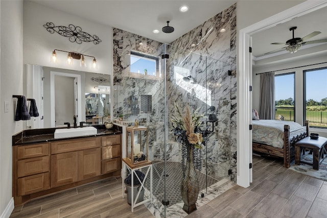 bathroom featuring a shower with door, ceiling fan, tile walls, and vanity