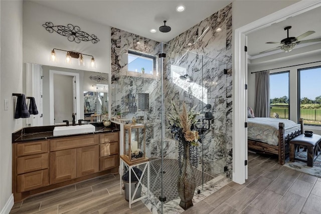 505 John Price St, Blanco, TX 78606 - full bathroom featuring a marble finish shower, ensuite bathroom, wood finish floors, vanity, and a ceiling fan