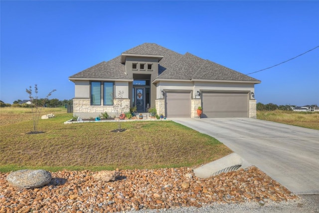 505 John Price St, Blanco, TX 78606 - prairie-style house with stone siding, a garage, stucco siding, concrete driveway, and a front lawn