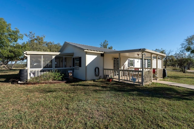 view of front of property featuring a sunroom, covered porch, and a front yard