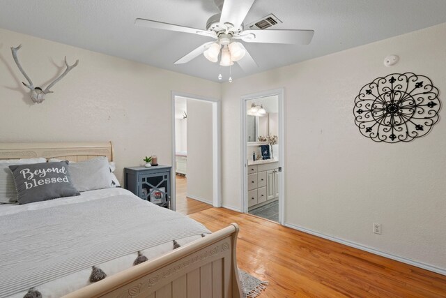 bedroom with ceiling fan, wood-type flooring, and connected bathroom