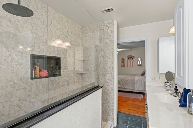 bathroom with ceiling fan, a fireplace, vanity, and tiled shower