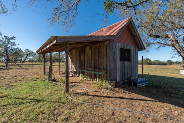 view of outdoor structure with a lawn and a rural view