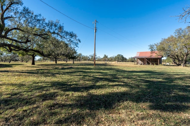 view of yard with a rural view and an outdoor structure