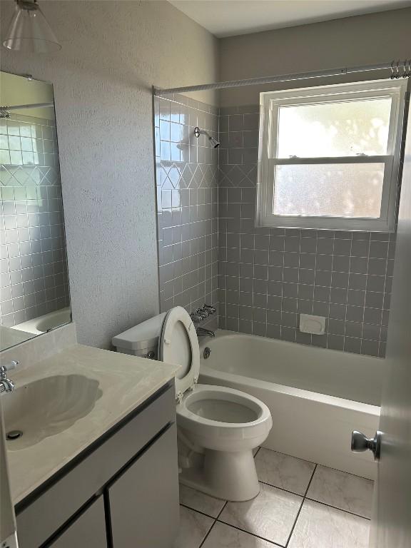 full bathroom with toilet, vanity, tile patterned floors, and tiled shower / bath