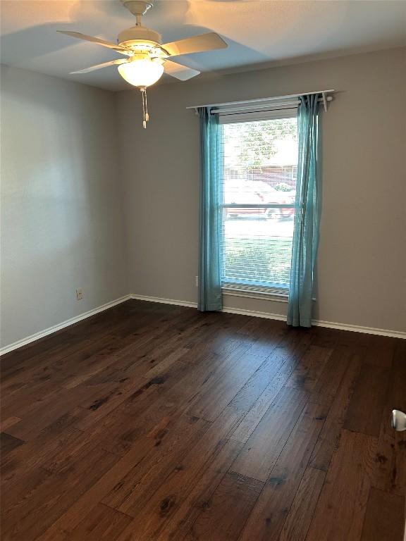 spare room with ceiling fan and dark wood-type flooring