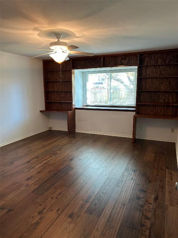 unfurnished room featuring a textured ceiling, ceiling fan, and dark wood-type flooring