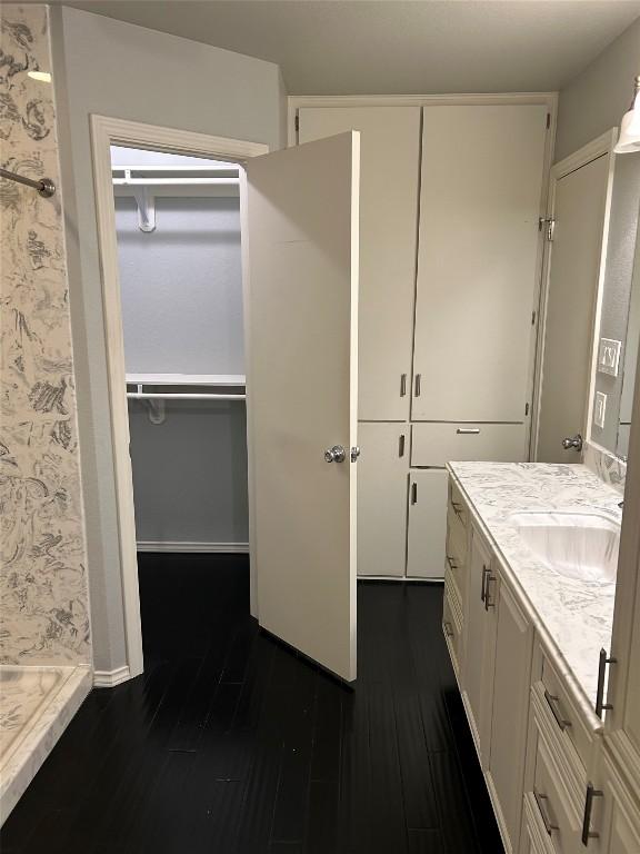 bathroom featuring hardwood / wood-style floors, vanity, and a shower