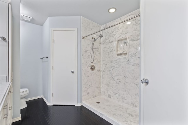 bathroom featuring visible vents, toilet, a stall shower, vanity, and wood finished floors