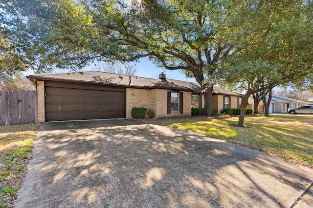 6803 Fence Line Dr, Austin, TX 78749 - view of front of home with concrete driveway, an attached garage, brick siding, and a chimney