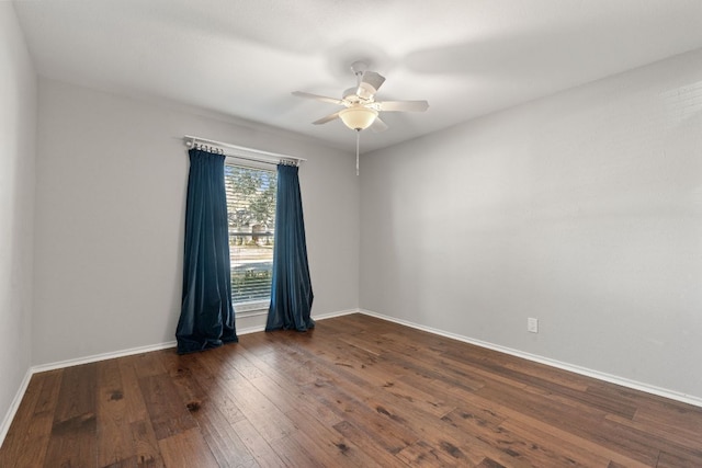 spare room with a ceiling fan, hardwood / wood-style flooring, and baseboards