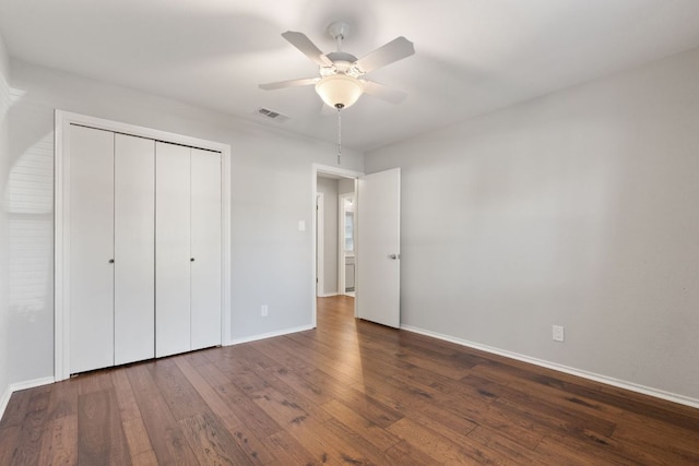 unfurnished bedroom with ceiling fan, visible vents, baseboards, a closet, and wood-type flooring