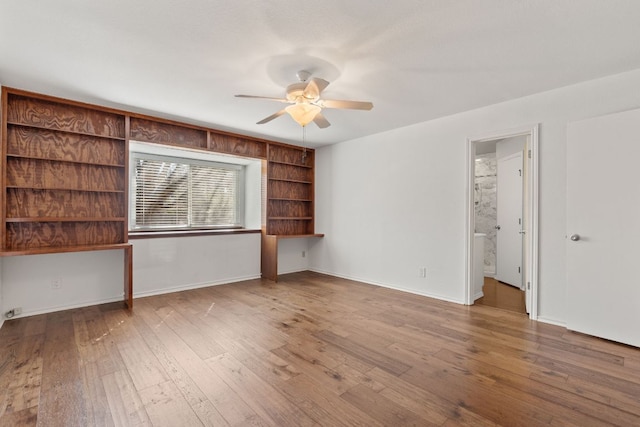 6803 Fence Line Dr, Austin, TX 78749 - empty room featuring a ceiling fan, hardwood / wood-style floors, baseboards, and built in shelves