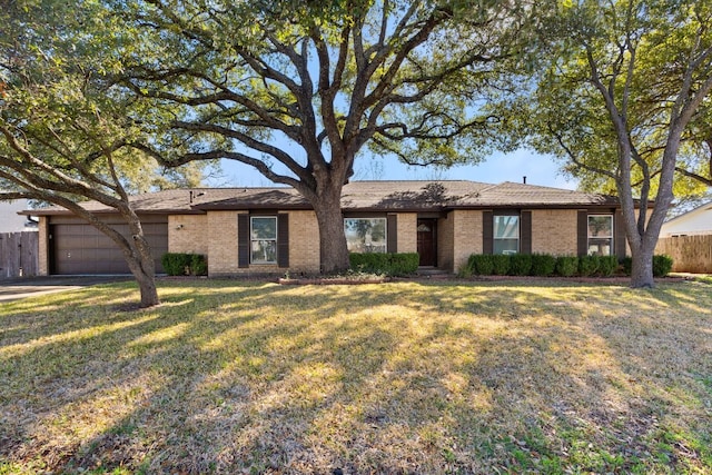 ranch-style house with a garage, brick siding, a front yard, and fence