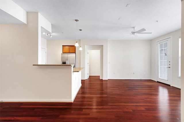 unfurnished living room with ceiling fan, a textured ceiling, and dark hardwood / wood-style floors