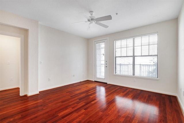 empty room with dark hardwood / wood-style floors and ceiling fan