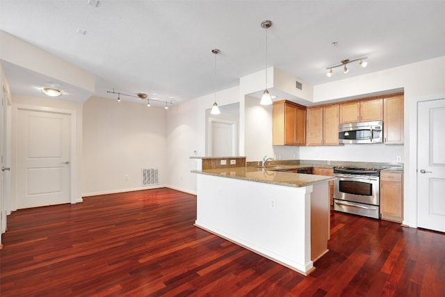 kitchen with appliances with stainless steel finishes, kitchen peninsula, decorative light fixtures, dark wood-type flooring, and light stone counters