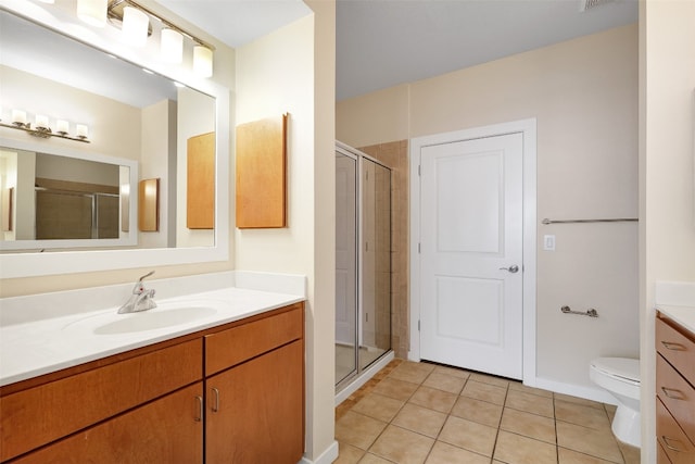 bathroom with vanity, tile patterned flooring, toilet, and a shower with door