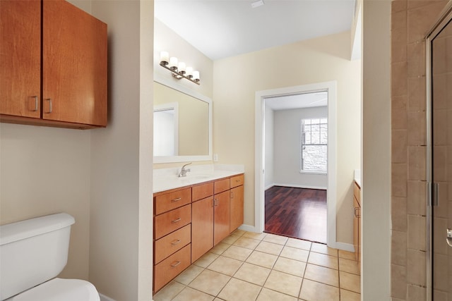 bathroom with vanity, toilet, tile patterned floors, and a shower with shower door