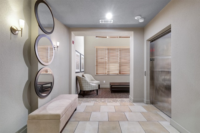 bathroom featuring a textured ceiling and tile patterned flooring