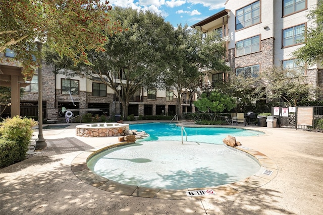 view of swimming pool with a patio and a community hot tub