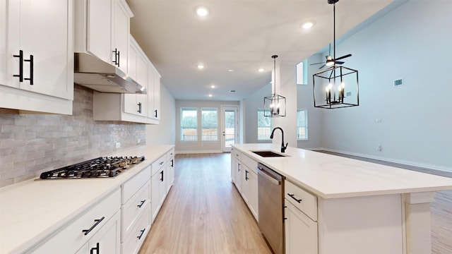 kitchen featuring sink, hanging light fixtures, an island with sink, white cabinetry, and stainless steel appliances