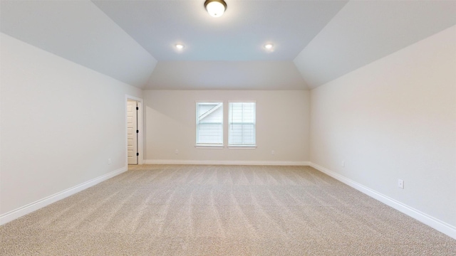 interior space featuring light colored carpet and lofted ceiling