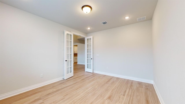 empty room with french doors and light wood-type flooring