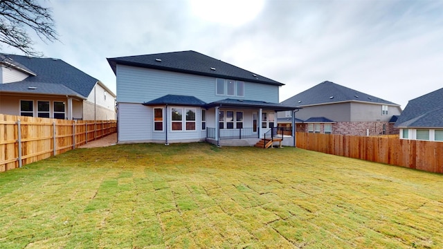 rear view of house with covered porch and a lawn