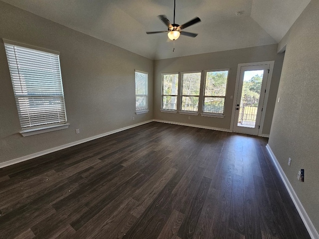 empty room with dark hardwood / wood-style floors, ceiling fan, and vaulted ceiling