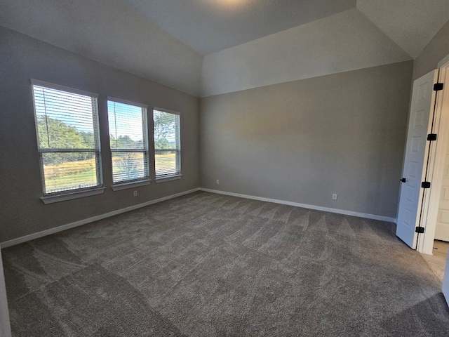 carpeted spare room with lofted ceiling