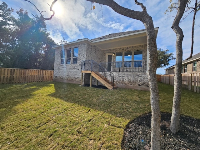 1709 Garret Oaks Ln, Georgetown, TX 78633 - rear view of house with brick siding, a fenced backyard, and stairway