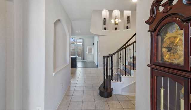 entrance foyer with light tile patterned flooring and an inviting chandelier