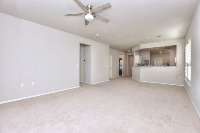 unfurnished living room featuring light colored carpet and ceiling fan